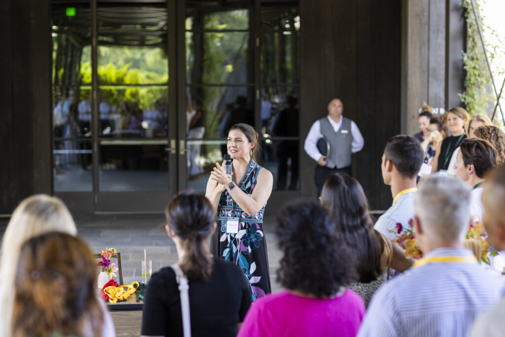 A speaker at a Giving Pledge event addressing a crowd.